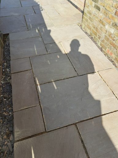 A stone pathway casting a shadow of a person beside it.