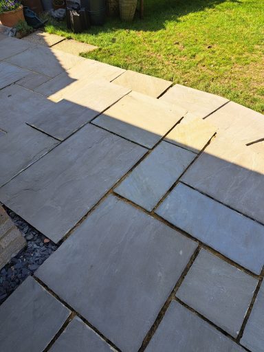 Paved pathway composed of large, irregular stone slabs and surrounding grass.