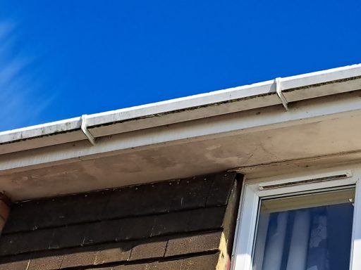 Close-up of a building's eaves against a clear blue sky.