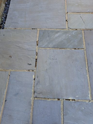 Uneven stone paving stones in varying shades of grey and beige.