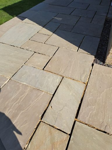 Irregular stone paving with a mix of light and dark shades.
