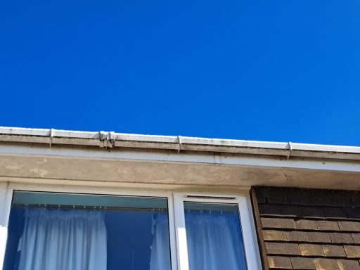 Close-up of a building's roofline against a clear blue sky.