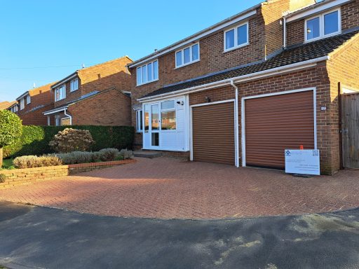 Front view of a modern house with a driveway and two garage doors.